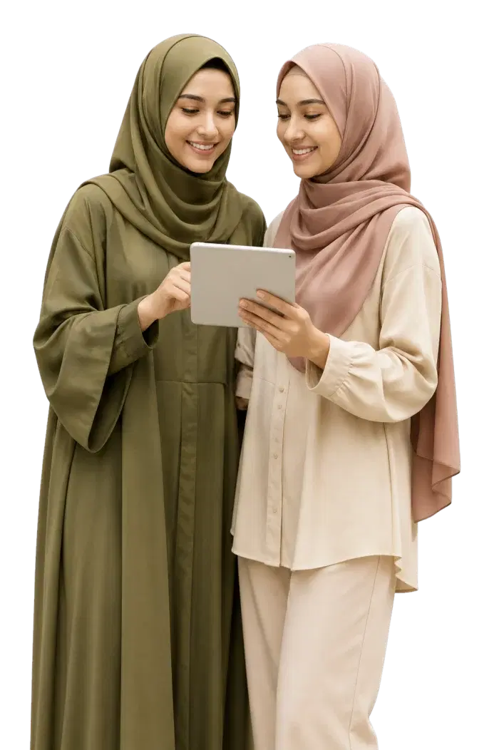 Two hijabi fashion professionals smiling at styling recommendations on a tablet